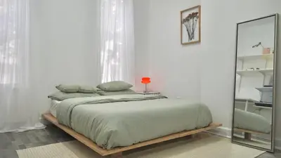 a bedroom with a large bed with a mirror at Cozy Private studio in Bushwick in Brooklyn
