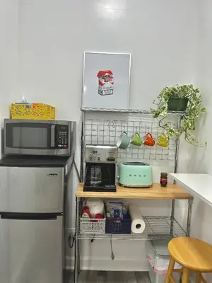 a kitchen with a counter with a microwave and a refrigerator at Cozy Private studio in Bushwick in Brooklyn