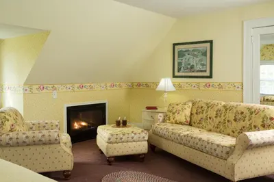 a living room with a couch and a fireplace at Four Chimneys Inn in Bennington