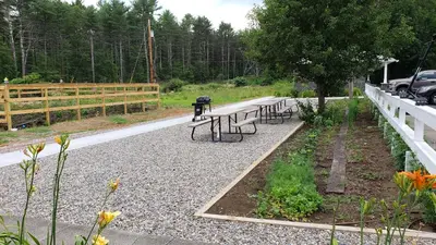 a group of benches sitting next to a fence at Sara Glen Motel - Saratoga Springs-Glens Falls in Saratoga Springs