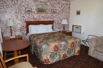 a hotel room with a bed and a table at Sara Glen Motel - Saratoga Springs-Glens Falls in Saratoga Springs