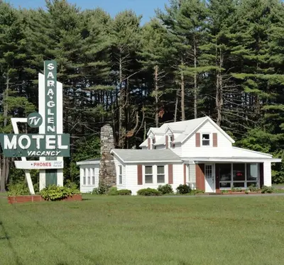 a motel sign in front of a house at Sara Glen Motel - Saratoga Springs-Glens Falls in Saratoga Springs