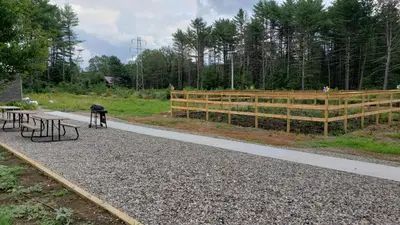 a park with benches and a wooden fence at Sara Glen Motel - Saratoga Springs-Glens Falls in Saratoga Springs
