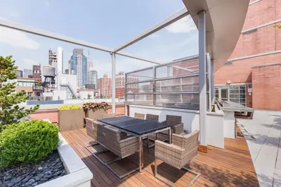 a balcony with a table and chairs on a building at Chelsea 1BR w Roof deck Gym Doorman NYC-122 in New York