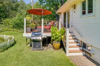 a patio with a grill and an umbrella next to a house at Pet-Friendly Staatsburg Studio - Near State Park in Staatsburg