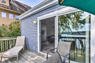 a porch with two chairs and a sliding glass door at Spacious Lakefront House With a Private Dock in Hopatcong