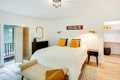 a white bedroom with a bed and a chair at Fully Remodeled Saugerties Retreat on 7 Acres! in Saugerties