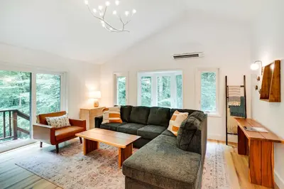a living room with a couch and a table at Fully Remodeled Saugerties Retreat on 7 Acres! in Saugerties
