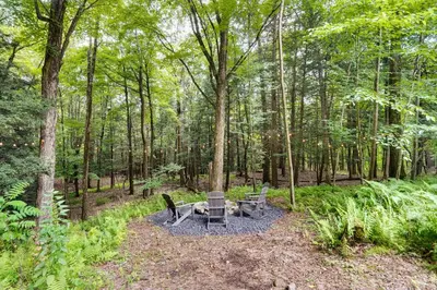 a picnic table and chairs in the woods at Fully Remodeled Saugerties Retreat on 7 Acres! in Saugerties