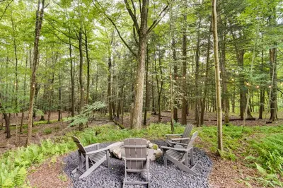 two chairs and a table in the woods at Fully Remodeled Saugerties Retreat on 7 Acres! in Saugerties