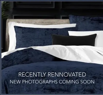 a bed with blue and white sheets and pillows at The Stockade Inn in Schenectady