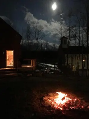 a fire in a yard at night with the moon at Sadawga Springs Retreat in Whitingham