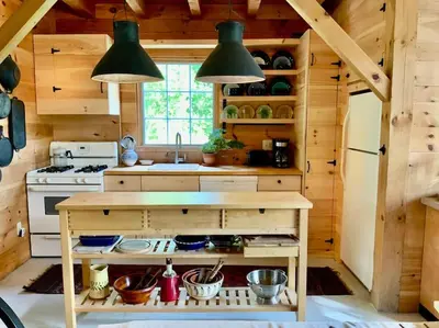 a kitchen with a stove and a sink in a cabin at Sadawga Springs Retreat in Whitingham