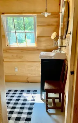 a bathroom with a sink and a chair and a window at Sadawga Springs Retreat in Whitingham