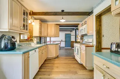 a large kitchen with wooden cabinets and blue counter tops at Sparrow Bush Retreat with Pool and Screened Porch in Sparrow Bush