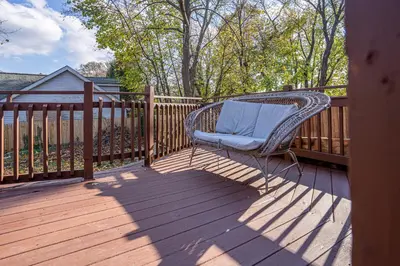 a wicker chair sitting on a wooden deck at H2 1 Bedroom Downtown Stamford in Stamford