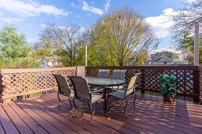 a patio with a table and chairs on a wooden deck at H2 1 Bedroom Downtown Stamford in Stamford
