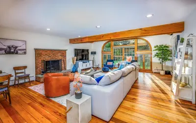 a living room with a white couch and a fireplace at Mountain Blue Vista - Luxury retreat near Ski resorts with Pond, Firepit and Hot Tub in Windham