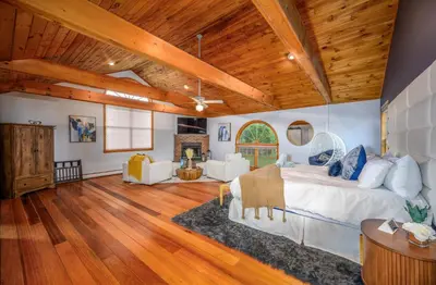 a bedroom with a large bed and wooden ceilings at Mountain Blue Vista - Luxury retreat near Ski resorts with Pond, Firepit and Hot Tub in Windham