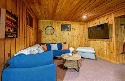 a living room with a blue couch and a table at Mountain Blue Vista - Luxury retreat near Ski resorts with Pond, Firepit and Hot Tub in Windham