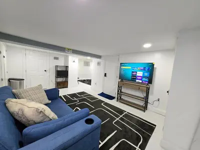 a living room with a blue couch and a flat screen tv at Large Group Home NJ Close To NYC Train in Boonton