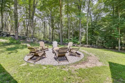 a group of chairs and tables in a yard at Lakefront New York Abode with Deck, Grill and Fire Pit in Mahopac