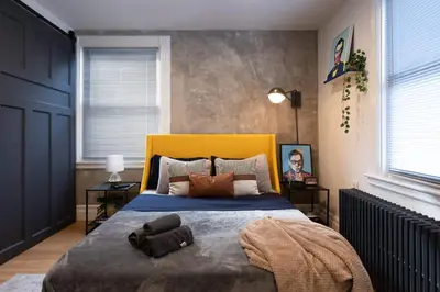 a bedroom with a bed with a blue blanket on it at Urban Bedroom in Mount Vernon