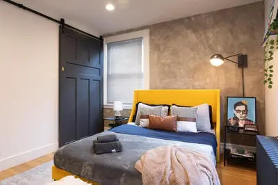 a bedroom with a large bed with a yellow headboard at Urban Bedroom in Mount Vernon