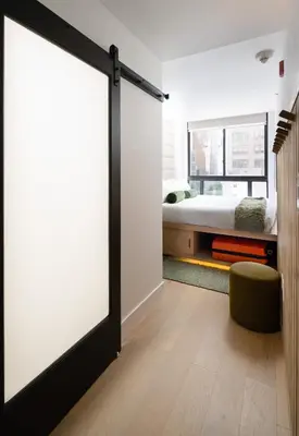 a sliding door in a bedroom with a bed at Little Charlie Hotel in New York