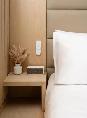 a bed with a clock on a night stand next to a bed at Little Charlie Hotel in New York