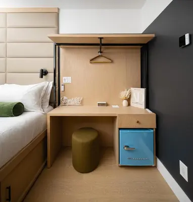 a bedroom with a desk and a bed with a bed at Little Charlie Hotel in New York