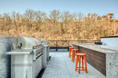 a patio with a grill and orange bar stools at Hoboken 2BR w Doorman Gym WD nr shuttle NYC-717 in Hoboken