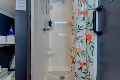 a shower with a shower curtain with flowers on it at The Little Villa - 2Bed 1Bath Private Suite in Bristol