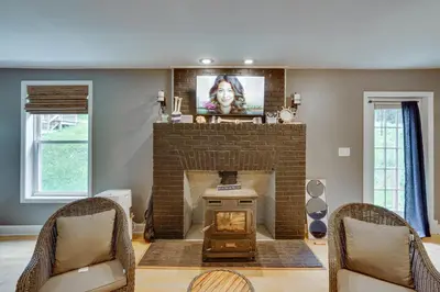 a living room with a fireplace and a tv at Lakefront West Sand Lake Home with Beach Access! in West Sand Lake
