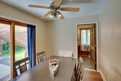 a dining room with a table and a ceiling fan at Lakefront West Sand Lake Home with Beach Access! in West Sand Lake