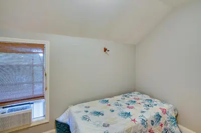 a bedroom with a bed and a window at Lakefront West Sand Lake Home with Beach Access! in West Sand Lake