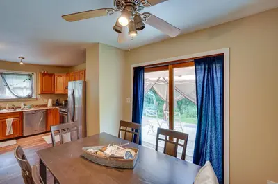 a kitchen and dining room with a table and a ceiling fan at Lakefront West Sand Lake Home with Beach Access! in West Sand Lake