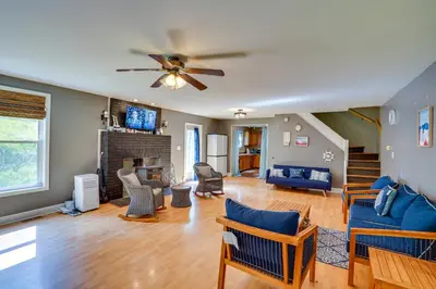 a living room with a couch and a ceiling fan at Lakefront West Sand Lake Home with Beach Access! in West Sand Lake