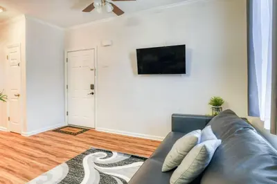 a living room with a couch and a flat screen tv at TWO Modern Apartment Minutes to NYC in Jersey City