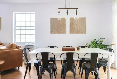 a dining room with a white table and black chairs at Catskill Cabin with Firepit & Indoor Jacuzzi Tub in Catskill