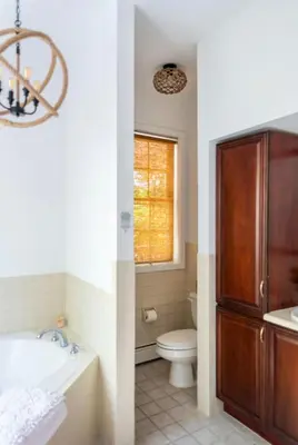 a bathroom with a toilet and a sink and a tub at Catskill Cabin with Firepit & Indoor Jacuzzi Tub in Catskill