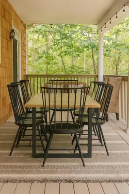 a wooden table and chairs on a porch at Catskill Cabin with Firepit & Indoor Jacuzzi Tub in Catskill