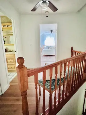 a wooden staircase with a ceiling fan in a room at Catskill Cabin with Firepit & Indoor Jacuzzi Tub in Catskill
