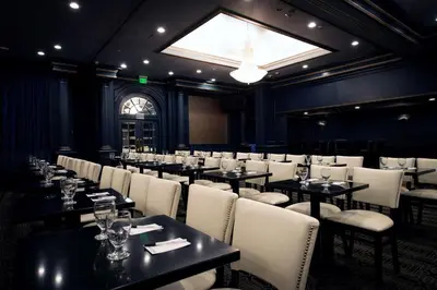 a restaurant with tables and white chairs and a window at The Roslyn, Tapestry Collection by Hilton in Roslyn