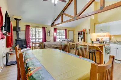 a kitchen and dining room with a table and a stove at Pools and Ski Access Lackawaxen Cottage with Deck! in Lackawaxen