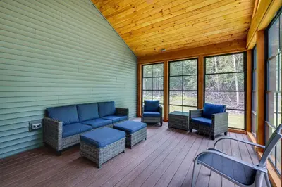 a screened in porch with blue furniture and windows at Cresco Countryside Oasis Surrounded by Nature! in Cresco