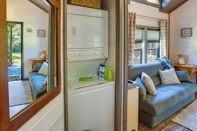 a tiny house with a kitchen and a couch at Mayfield Tiny Home with Porch, Walk to Beaches! in Benson