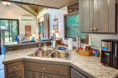 a kitchen with a sink and a counter top at Mayfield Tiny Home with Porch, Walk to Beaches! in Benson