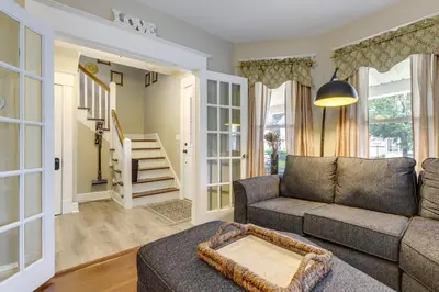 a living room with a couch and a staircase at 3 Mi to Dtwn Springfield Winter Retreat with Office in Springfield