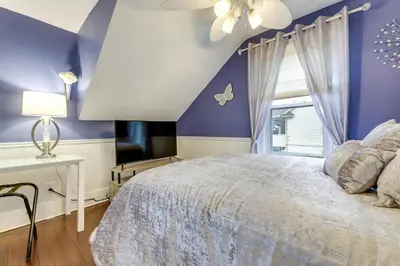 a bedroom with purple walls and a bed with a window at 3 Mi to Dtwn Springfield Winter Retreat with Office in Springfield